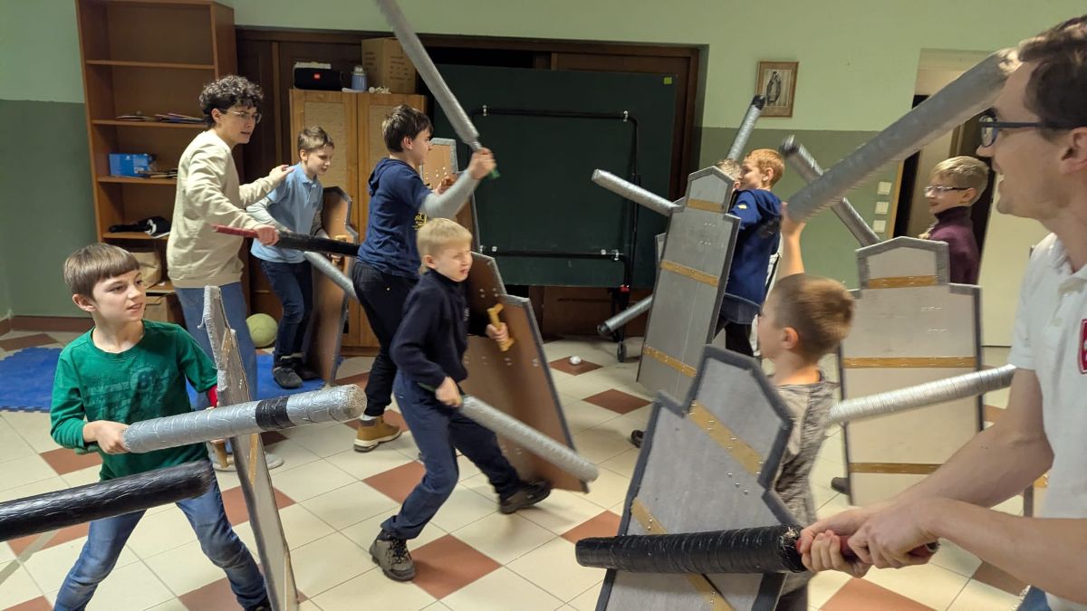 Skupina chlapcov bojuje proti sebe s mečmi